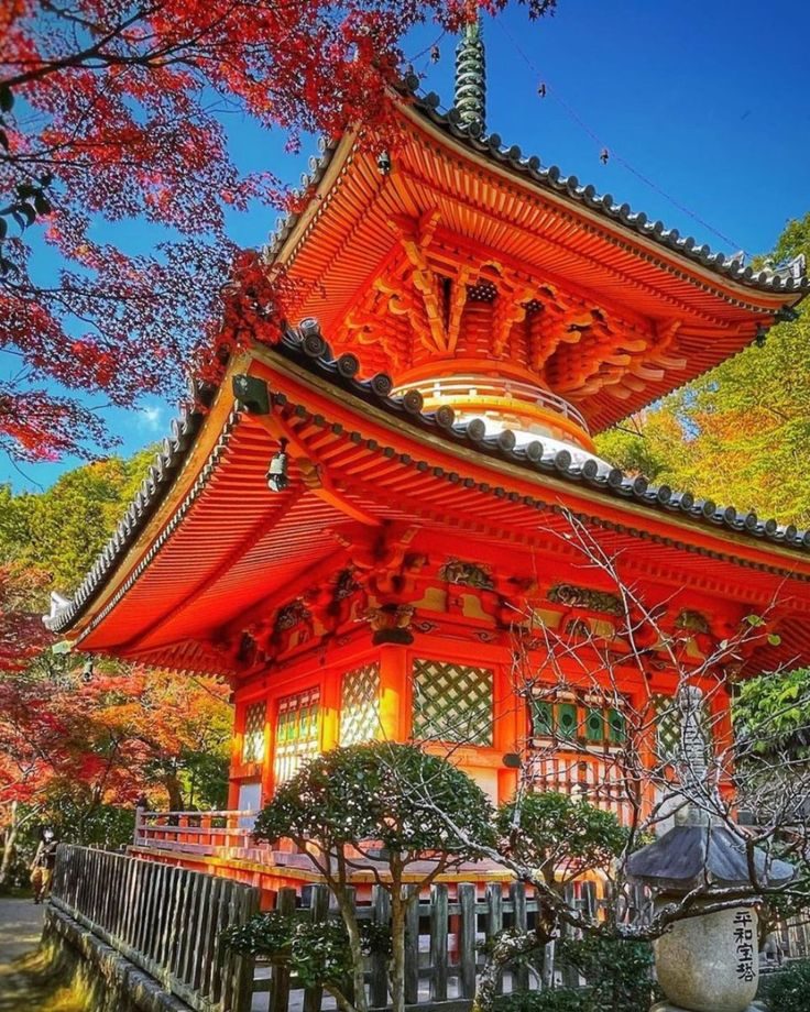 Pagode rouge aux toits superposés, entourée d’érables rouges d’automne